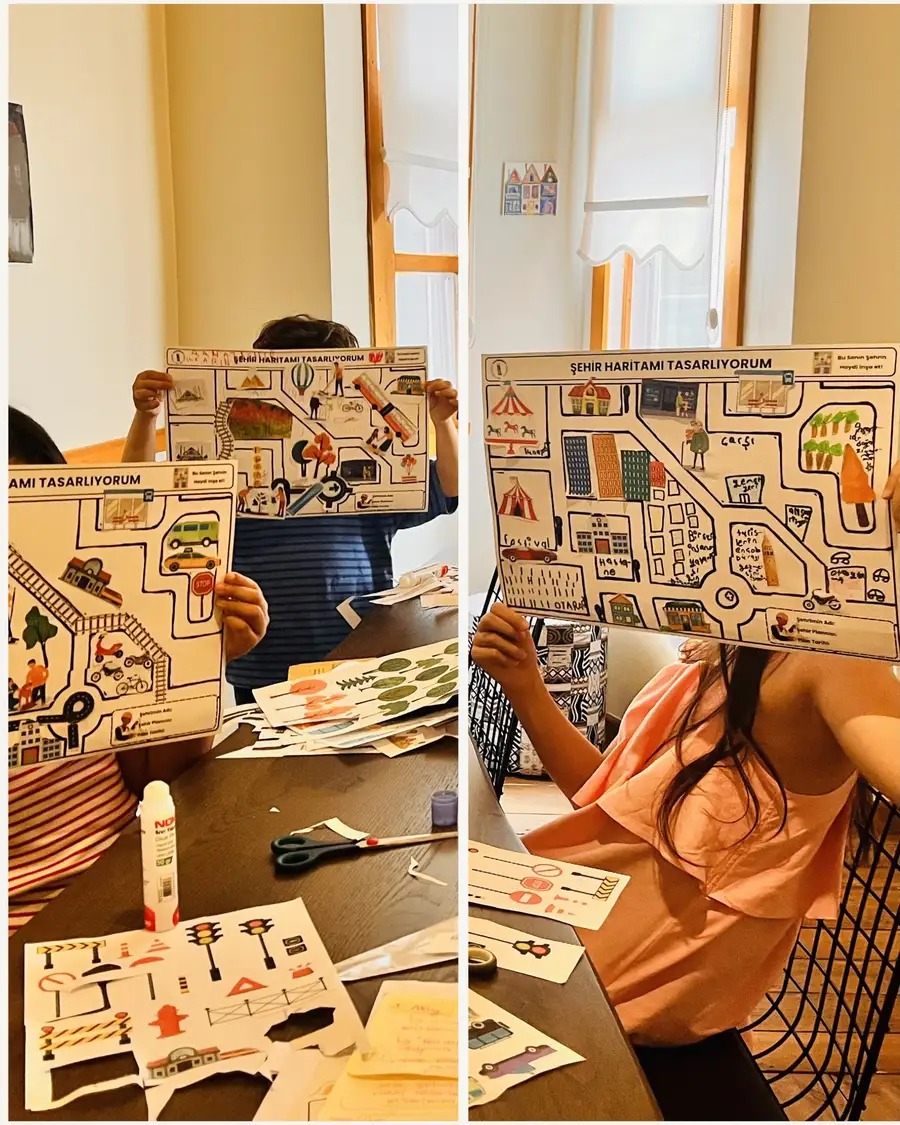 Tamamlanmış şehir haritalarını gösteren çocuklar